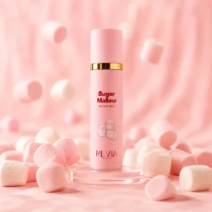 Pink perfume spray bottle labeled Sugar Mallow on a clear stand, surrounded by pink marshmallows against a soft pink background.